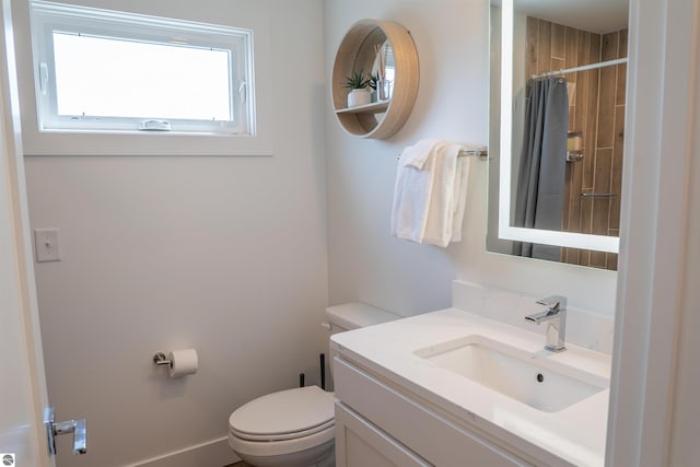 full bath with toilet, a shower with shower curtain, and vanity