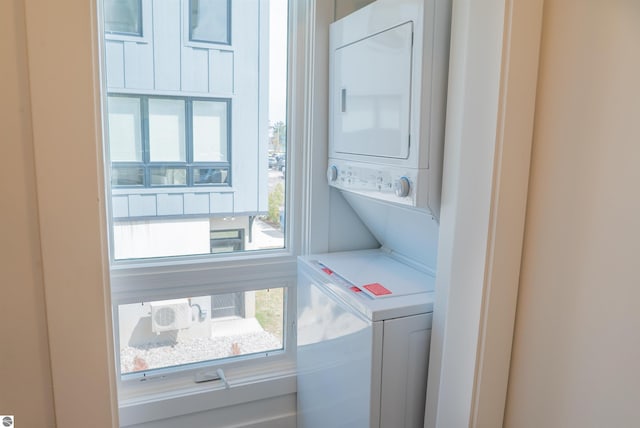 washroom featuring stacked washer and clothes dryer