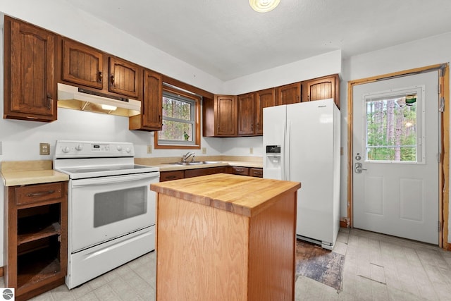 kitchen featuring under cabinet range hood, white appliances, wood counters, a sink, and a center island