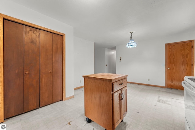 kitchen with light flooring, wooden counters, white range with electric stovetop, and baseboards