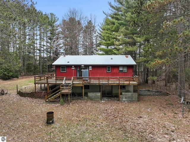 view of front of house featuring a deck, metal roof, and stairway