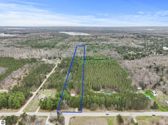 aerial view of property's location with a heavily wooded area and property parcel outlined
