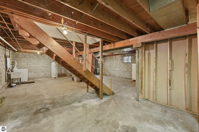 basement with stairway, a sink, and water heater