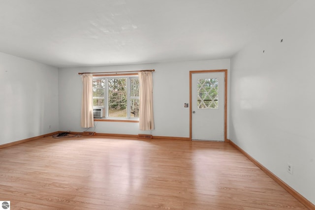 unfurnished living room with light wood-type flooring and baseboards