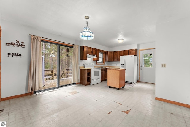 kitchen with white appliances, under cabinet range hood, baseboards, light countertops, and light flooring