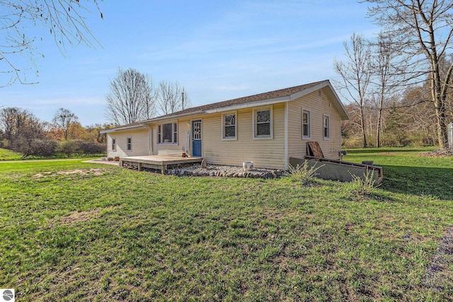 4507 Maidens Rd, Onekama, MI 49675 - ranch-style house with a front yard and a wooden deck