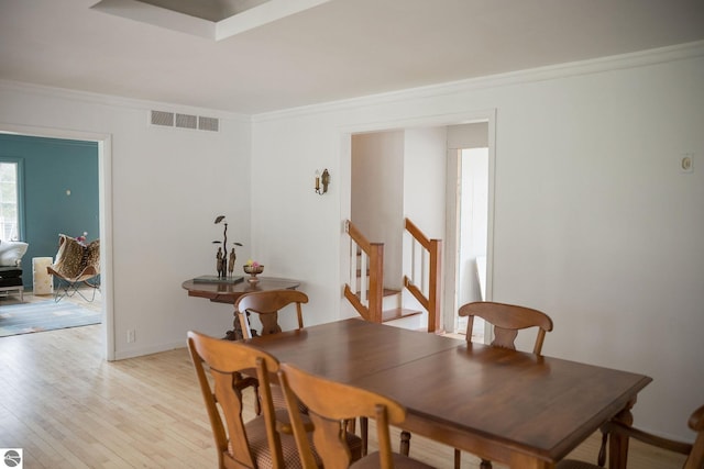3080 N Lake Leelanau Dr, Lake Leelanau, MI 49653 - dining room with crown molding, light wood-style flooring, and stairway