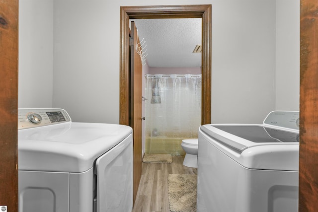 3610 S Call Rd, Lake City, MI 49651 - washroom featuring washer and dryer, wood finished floors, and a textured ceiling