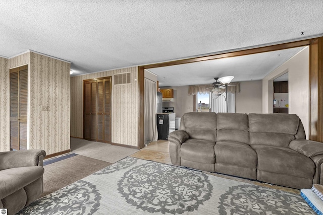 3610 S Call Rd, Lake City, MI 49651 - living area with ceiling fan, a textured ceiling, light carpet, and wallpapered walls