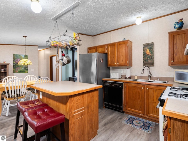 12036 SW Spring Creek Rd, Fife Lake, MI 49633 - kitchen with white appliances, brown cabinetry, light countertops, light wood-style floors, and a center island