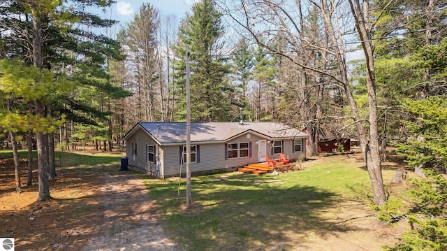 12036 SW Spring Creek Rd, Fife Lake, MI 49633 - view of front of home with a front yard, metal roof, crawl space, and a deck