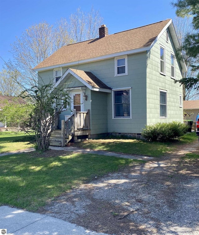 view of front facade featuring a chimney, a shingled roof, a front yard, and crawl space