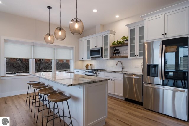 127 River St, Elk Rapids, MI 49629 - kitchen featuring appliances with stainless steel finishes, a sink, a kitchen island, wood finished floors, and recessed lighting