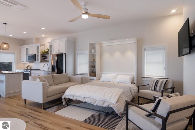 127 River St, Elk Rapids, MI 49629 - bedroom with stainless steel fridge, light wood-style flooring, recessed lighting, and a sink