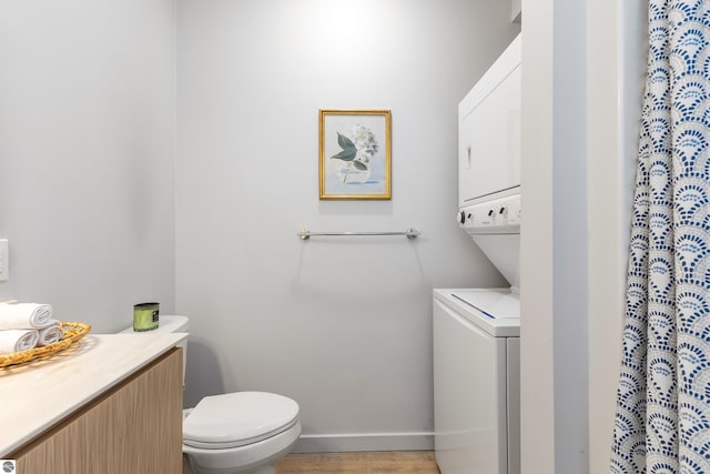 bathroom with toilet, wood finished floors, baseboards, curtained shower, and vanity