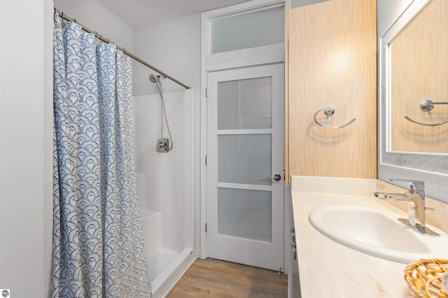 bathroom with a shower with shower curtain, wood finished floors, and vanity