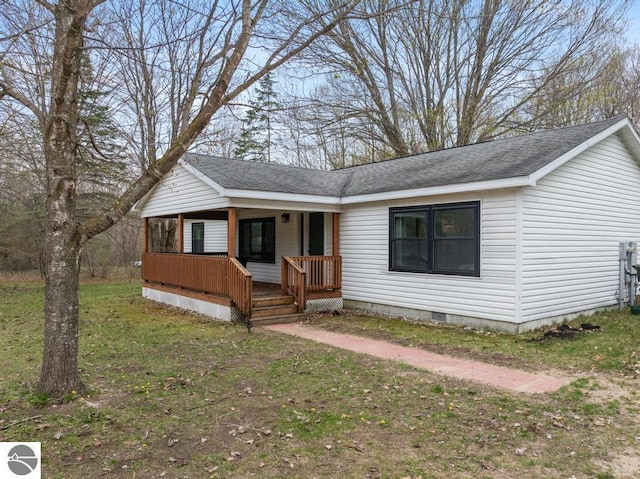11420 Muskie Way, Ellsworth, MI 49729 - view of front facade with covered porch, a shingled roof, crawl space, and a front lawn