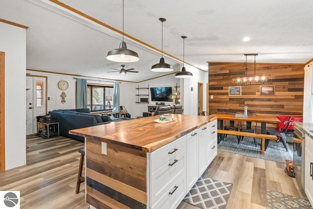 11420 Muskie Way, Ellsworth, MI 49729 - kitchen featuring wooden counters, white cabinets, light wood-style flooring, open floor plan, and wooden walls