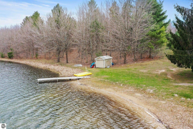 11531 S Tower Rd, Maple City, MI 49664 - view of yard featuring a storage unit, a water view, a dock, and an outdoor structure