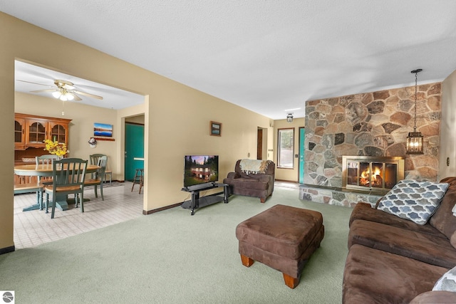 11531 S Tower Rd, Maple City, MI 49664 - living area featuring carpet flooring, a stone fireplace, a ceiling fan, and baseboards