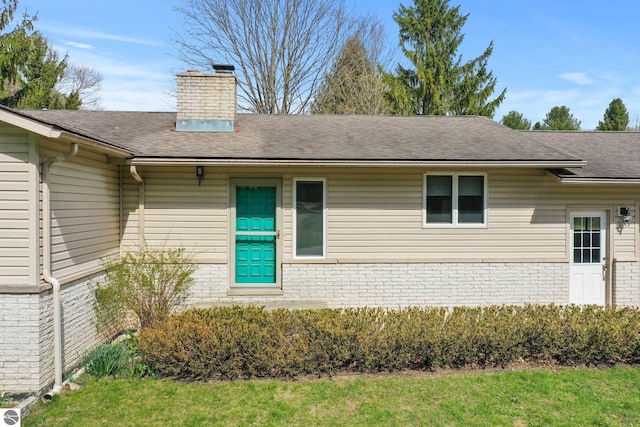 11531 S Tower Rd, Maple City, MI 49664 - view of front of house featuring brick siding, a chimney, and roof with shingles