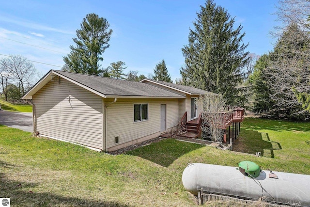 11531 S Tower Rd, Maple City, MI 49664 - view of side of property with a wooden deck, a yard, and roof with shingles