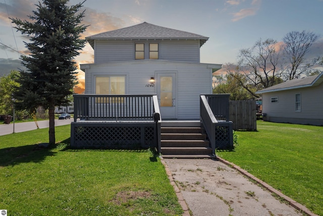 1040 Eastward St, Alma, MI 48801 - american foursquare style home featuring a deck, a front lawn, and roof with shingles