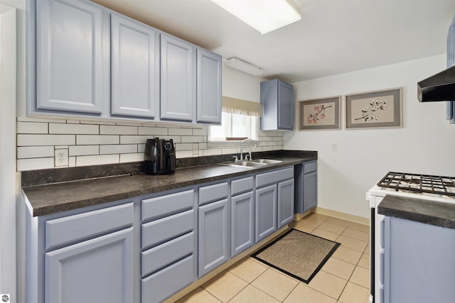 1040 Eastward St, Alma, MI 48801 - kitchen with a sink, white range with gas stovetop, dark countertops, and tasteful backsplash