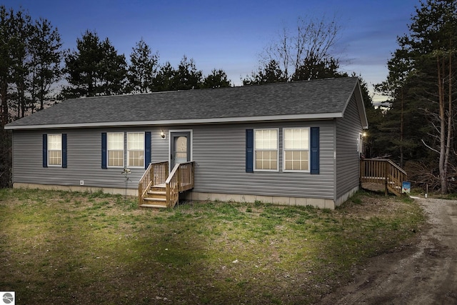 714 SE Saunders Rd, Kalkaska, MI 49646 - view of front of property featuring a front lawn and roof with shingles