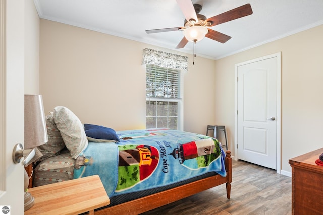 714 SE Saunders Rd, Kalkaska, MI 49646 - bedroom with wood finished floors, ornamental molding, a ceiling fan, and baseboards