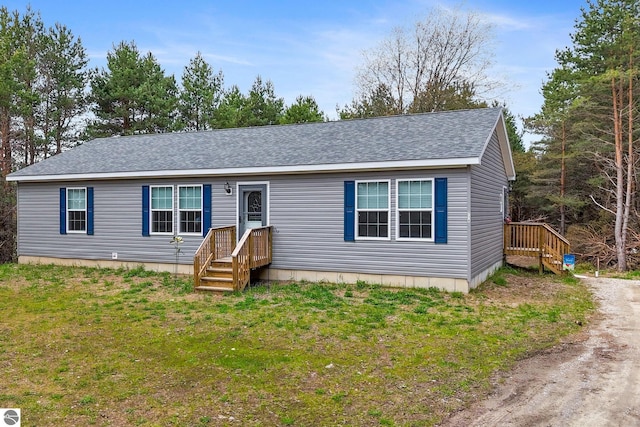 714 SE Saunders Rd, Kalkaska, MI 49646 - manufactured / mobile home with a shingled roof and a front yard