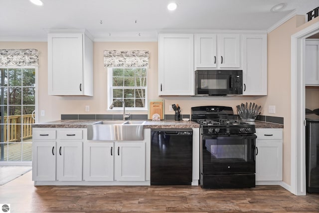 714 SE Saunders Rd, Kalkaska, MI 49646 - kitchen featuring black appliances, a sink, ornamental molding, healthy amount of natural light, and white cabinetry