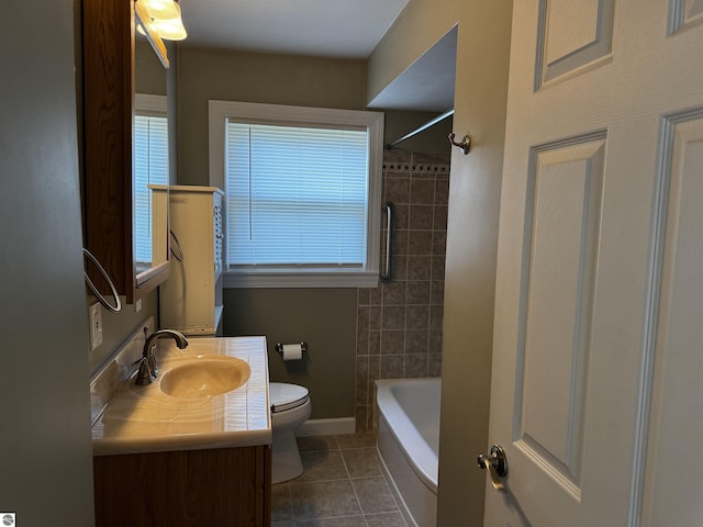 bathroom featuring tile patterned floors, toilet, vanity, baseboards, and tub / shower combination