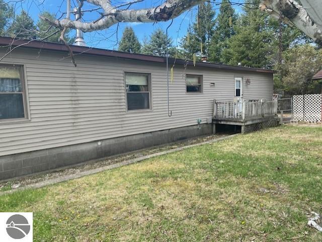 8067 Cherry Ave, Rapid City, MI 49676 - back of house featuring a deck, a lawn, and crawl space