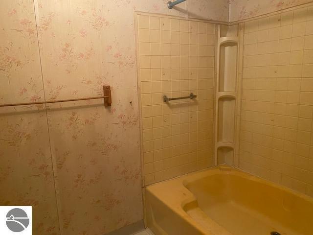 8067 Cherry Ave, Rapid City, MI 49676 - full bath with wallpapered walls and bathing tub / shower combination
