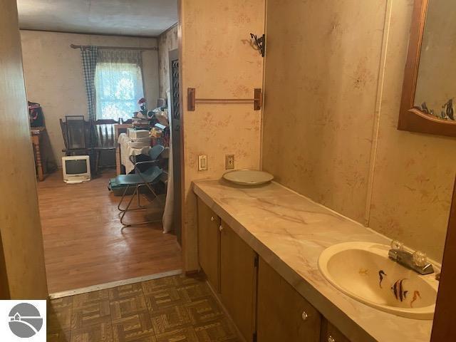 8067 Cherry Ave, Rapid City, MI 49676 - bathroom featuring wood finished floors and double vanity