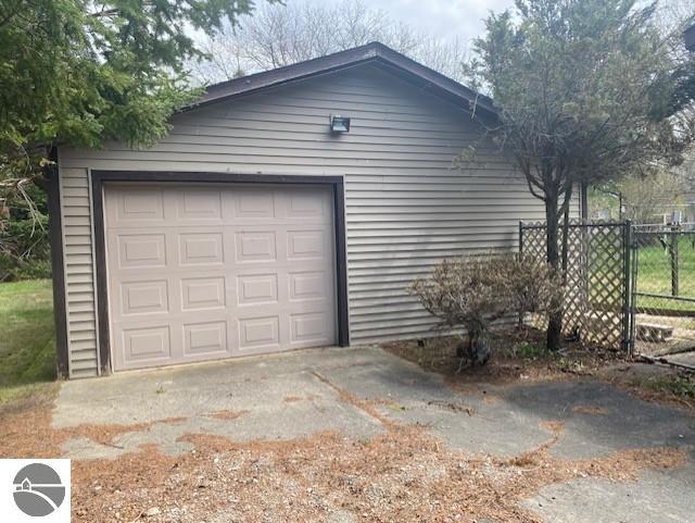 8067 Cherry Ave, Rapid City, MI 49676 - garage with driveway and fence