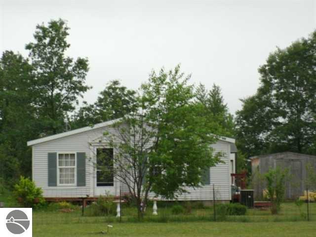 3072 Gonder Rd, Interlochen, MI 49643 - view of side of home with a storage shed, an outbuilding, a lawn, and central air condition unit