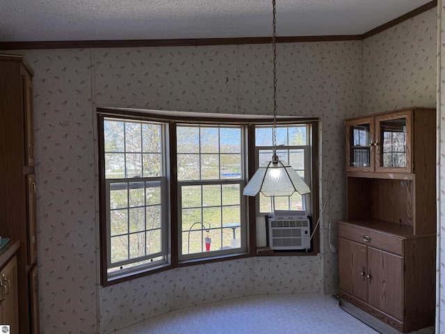 3072 Gonder Rd, Interlochen, MI 49643 - unfurnished dining area with crown molding, wallpapered walls, plenty of natural light, cooling unit, and a textured ceiling
