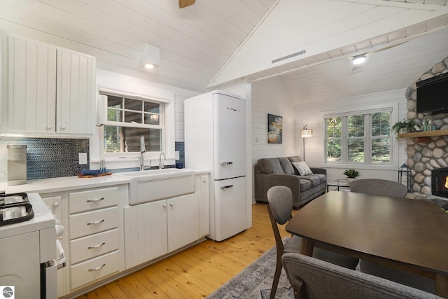 421 S Shabwasung St, Northport, MI 49670 - kitchen featuring freestanding refrigerator, stove, lofted ceiling, a sink, and wooden ceiling