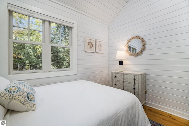 421 S Shabwasung St, Northport, MI 49670 - bedroom featuring lofted ceiling, wood finished floors, wooden walls, and baseboards