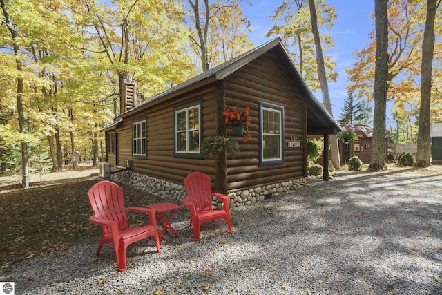 421 S Shabwasung St, Northport, MI 49670 - view of property exterior featuring a chimney, log exterior, and an outbuilding