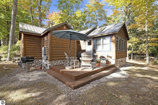 421 S Shabwasung St, Northport, MI 49670 - back of house with metal roof, faux log siding, and a deck