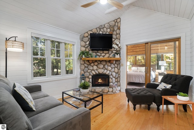 421 S Shabwasung St, Northport, MI 49670 - living area with lofted ceiling, a ceiling fan, hardwood / wood-style flooring, a fireplace, and wooden walls