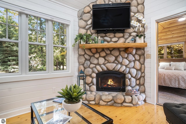 421 S Shabwasung St, Northport, MI 49670 - detailed view of wood finished floors, a stone fireplace, and wooden walls