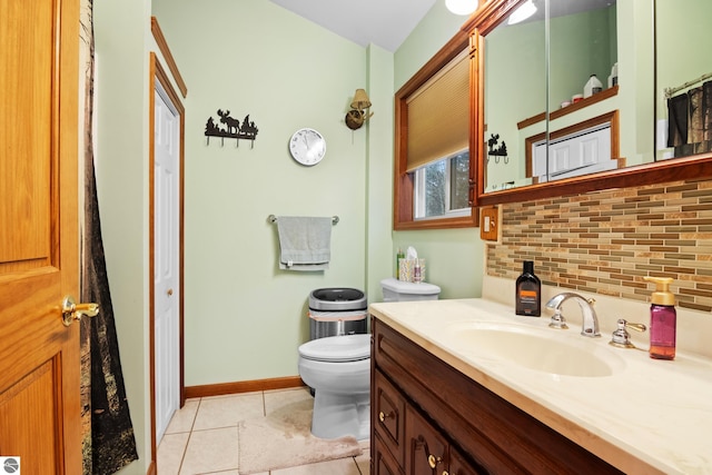 bathroom featuring tasteful backsplash, tile patterned floors, toilet, vanity, and baseboards