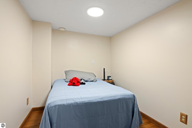 bedroom with dark wood-style flooring and baseboards