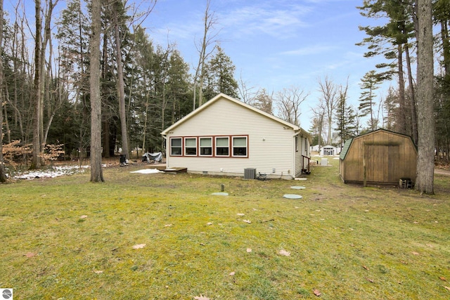 rear view of house featuring a shed, a lawn, and an outdoor structure