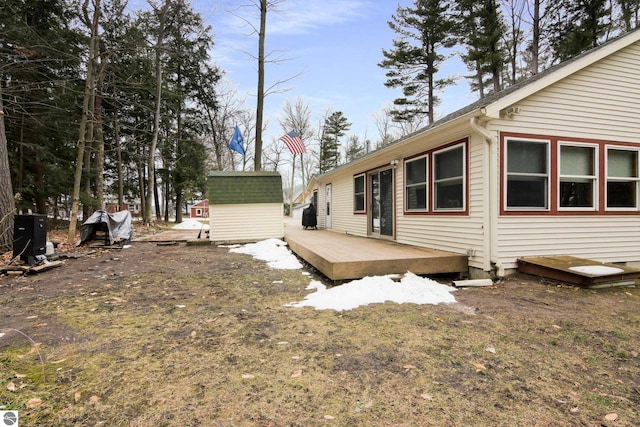 rear view of house featuring a shed, a wooden deck, and an outdoor structure