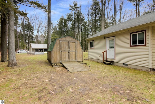 view of green lawn featuring entry steps, a shed, and an outbuilding